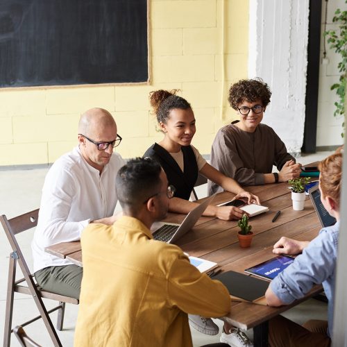 photo-of-people-leaning-on-wooden-table-3184614